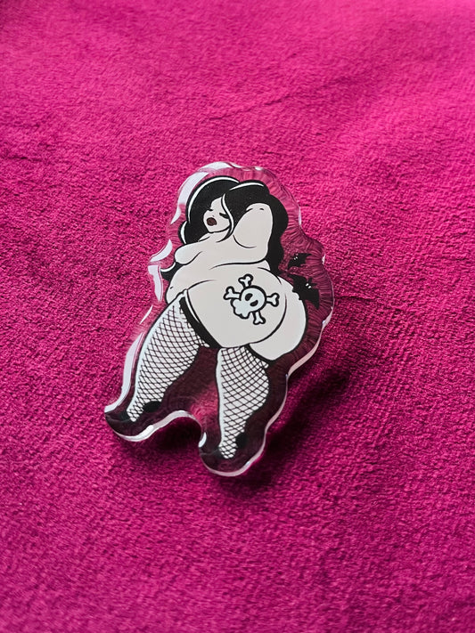 Pin with a design of a person in fishnet stockings and a skull on a pink background